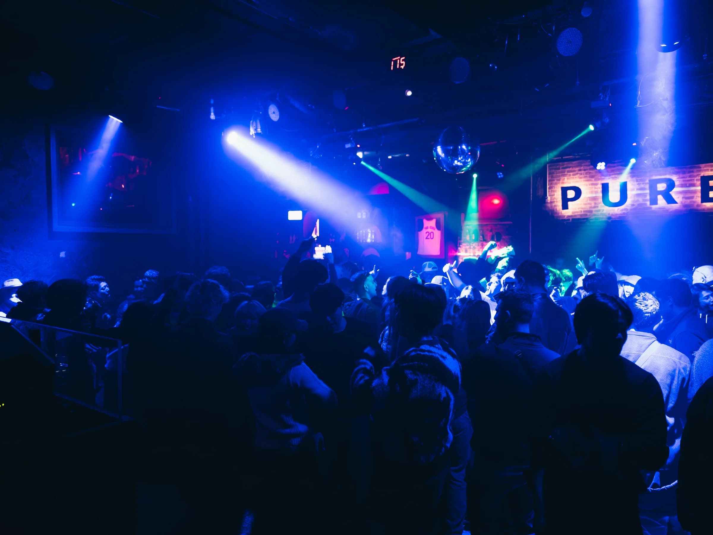 Blue-lit crowd filling the dance floor beneath the PURE Osaka sign