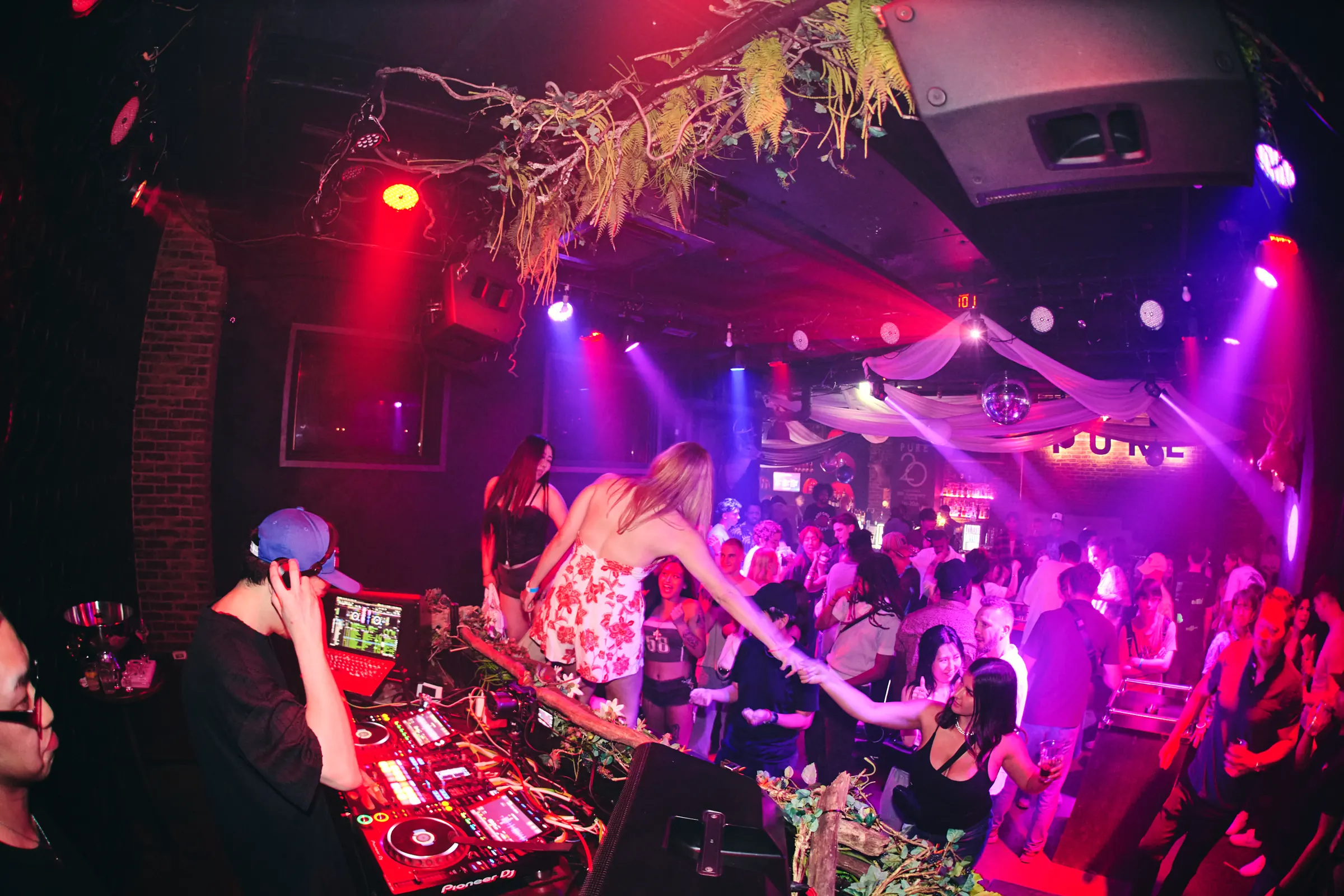 PUREのフロアで音に合わせて動く来場者とDJブース